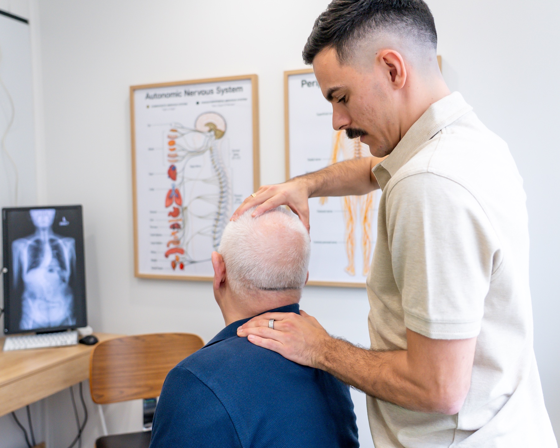 Dr Alex assessing a patient’s neck and movement at Alma Health