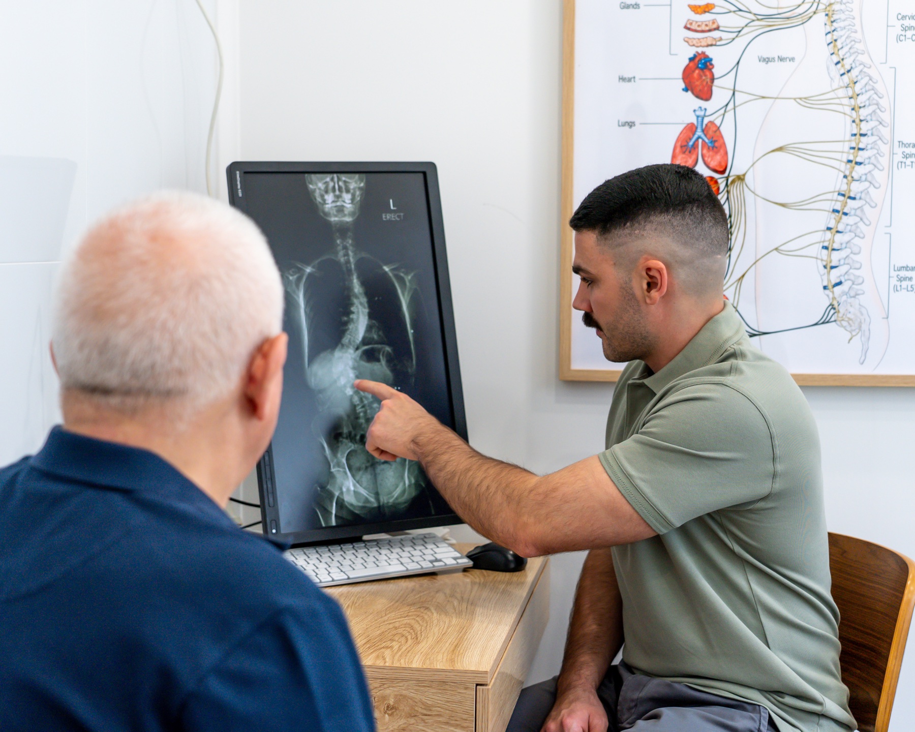 Dr Alex reviewing a spinal X-ray with a patient at Alma Health