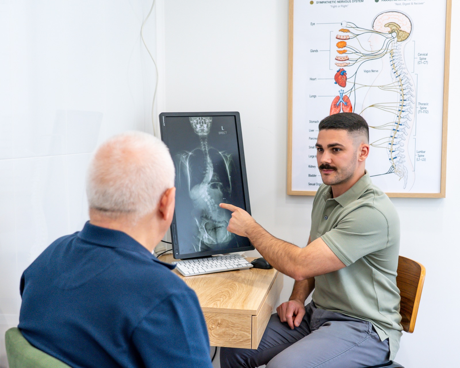 Alma Health chiropractor explaining spinal imaging and findings to a patient