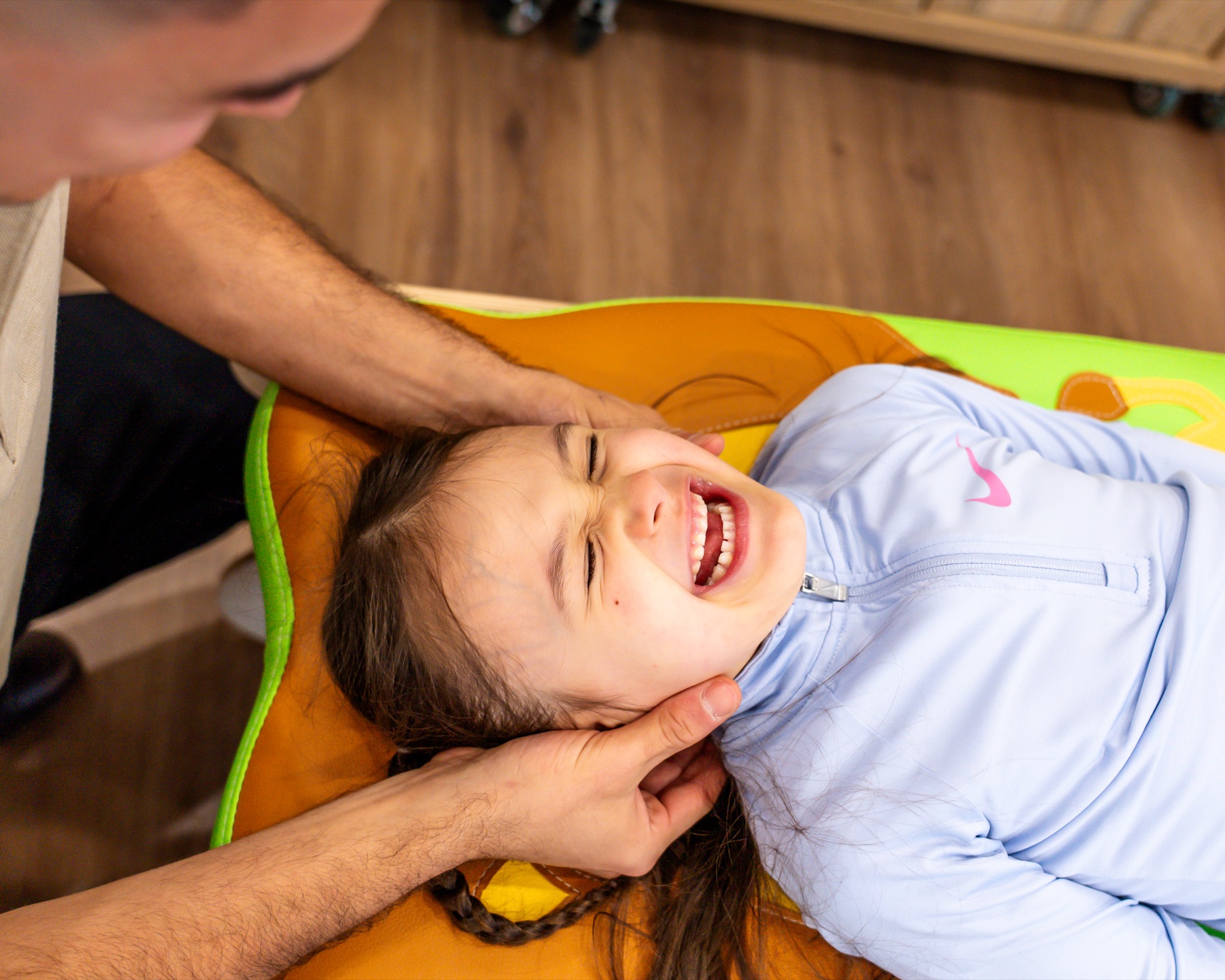 Child smiling during gentle chiropractic care at Alma Health