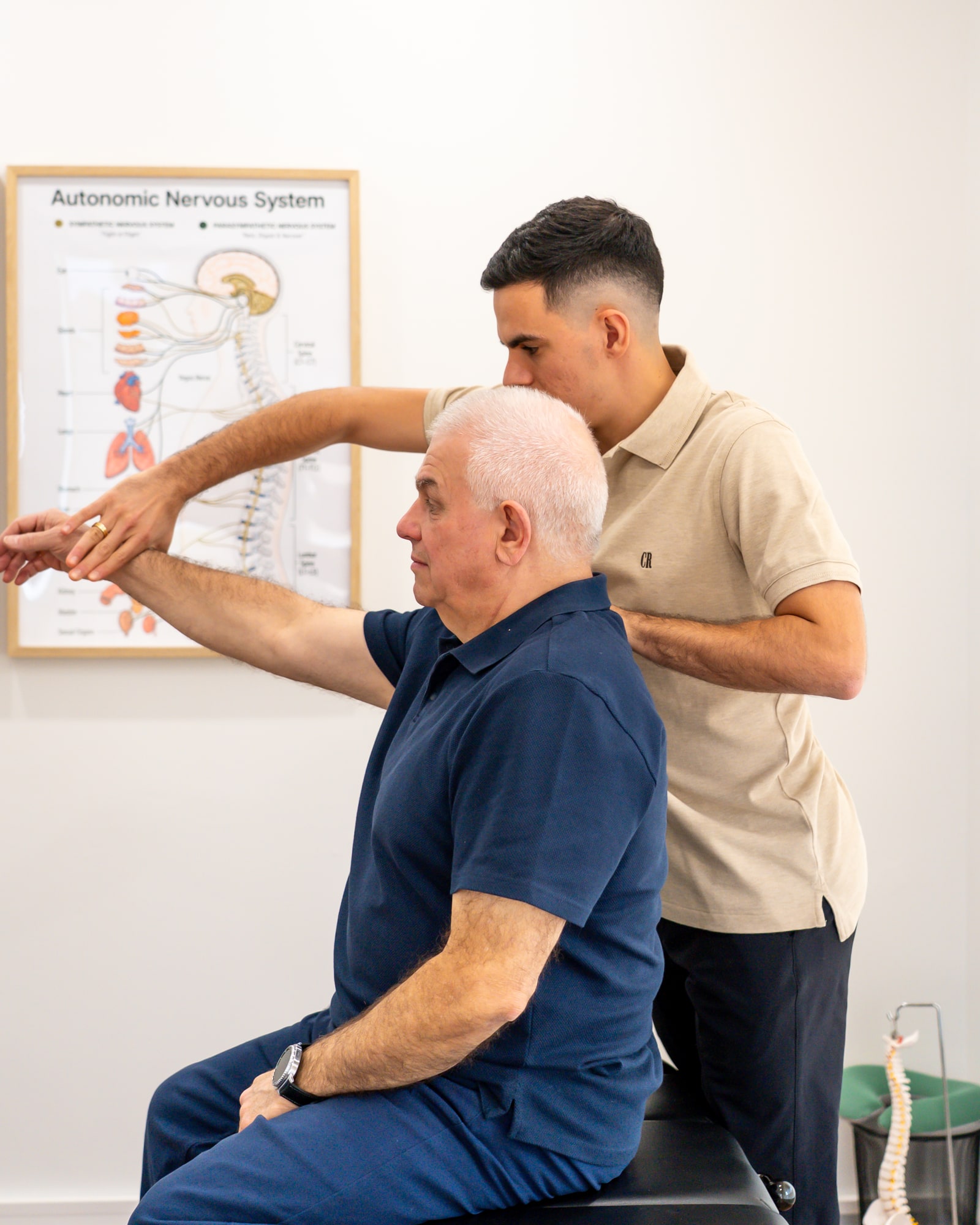 An Alma Health chiropractor assessing a patient’s shoulder movement